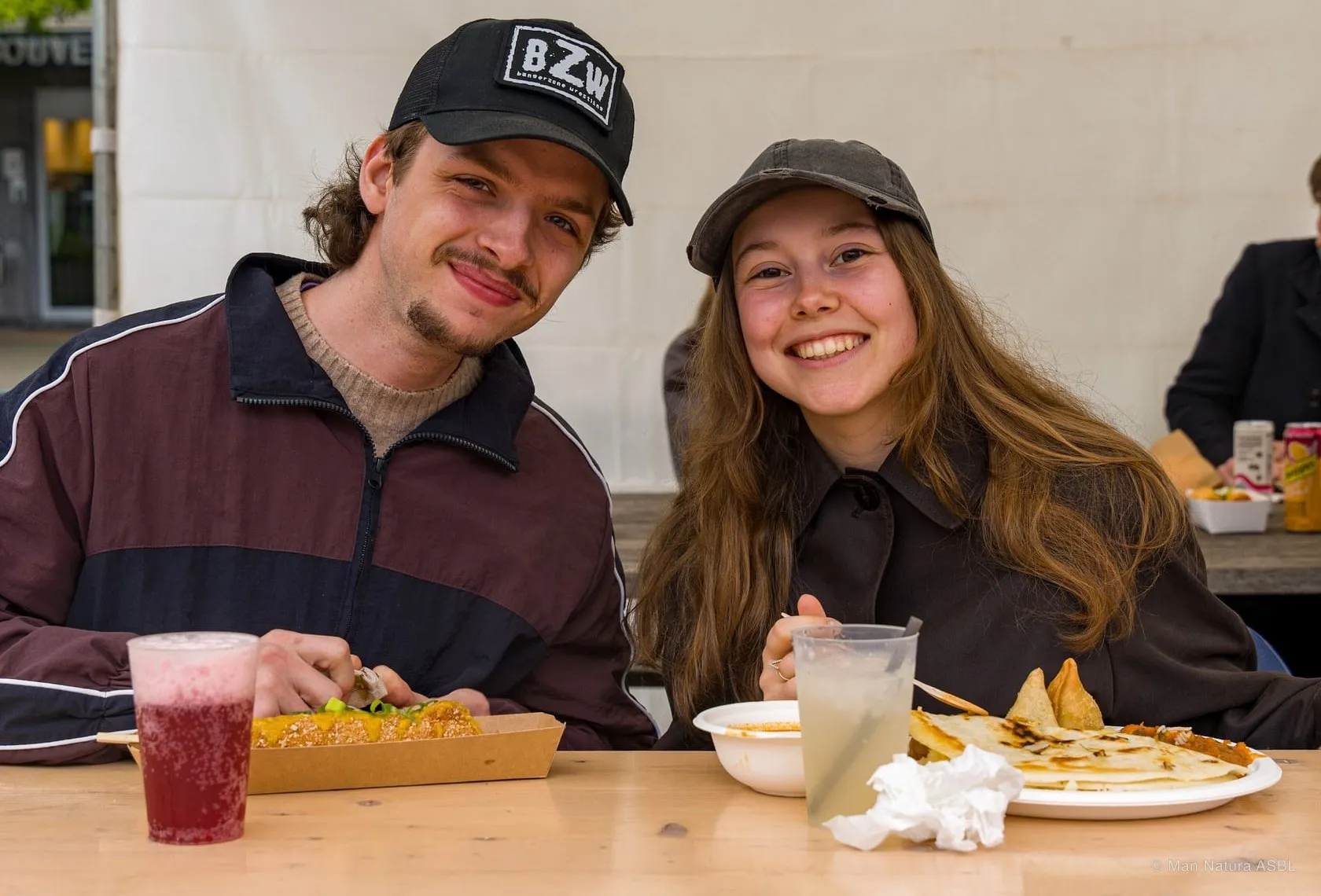 Deux visiteurs attablés devant leurs plats et leurs boissons