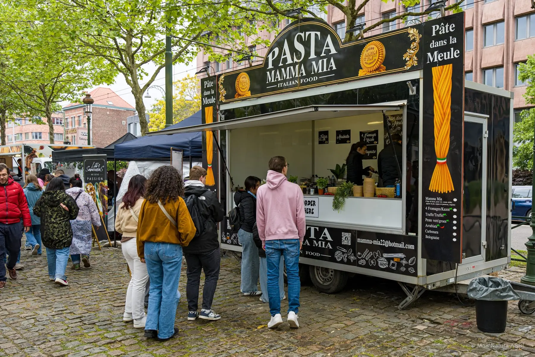 Le camion Pasta Mamma Mia et sa file de clients sous les arbres