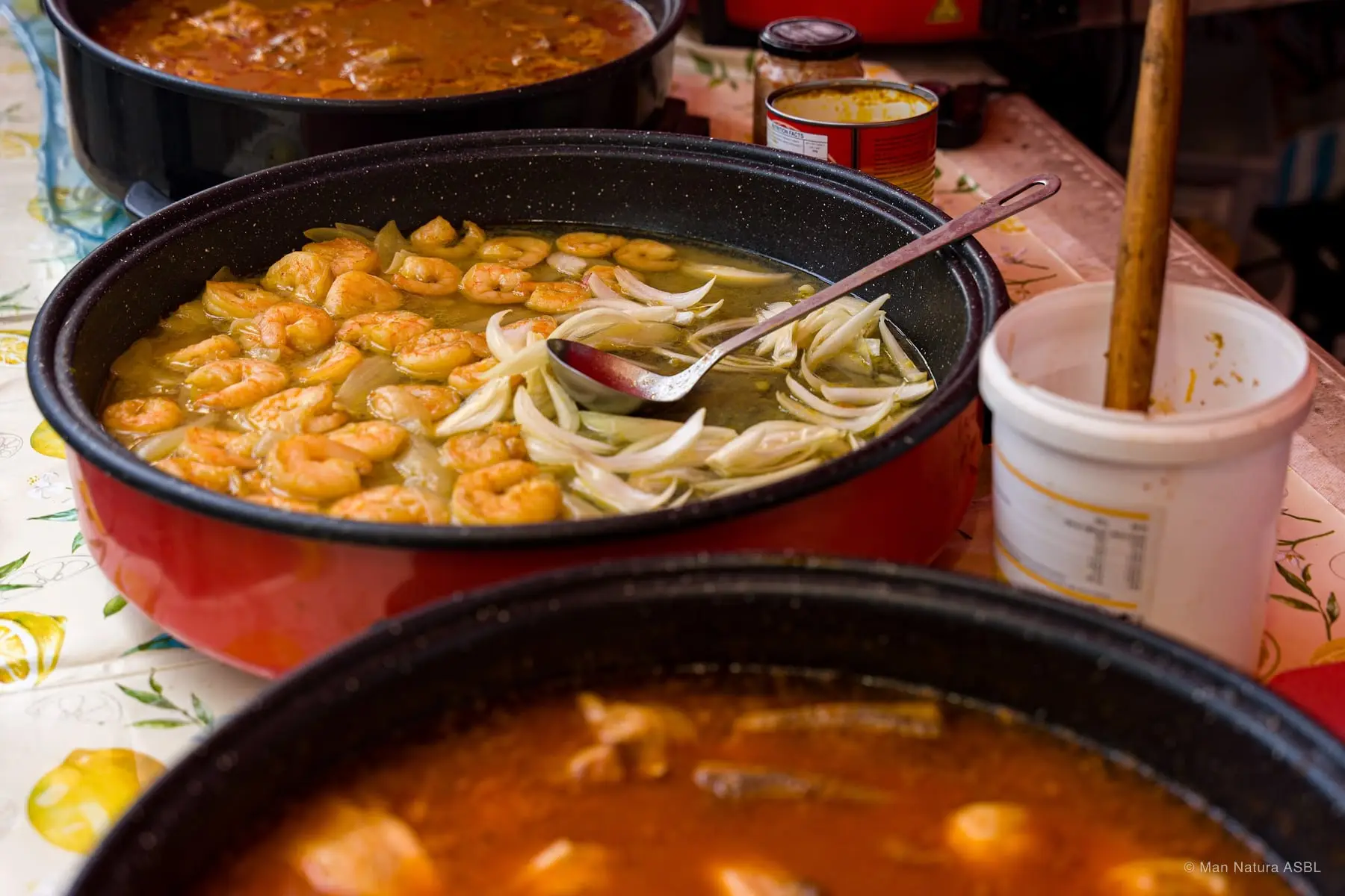 Grandes marmites de crevettes et de ragoût mijotant sur le stand