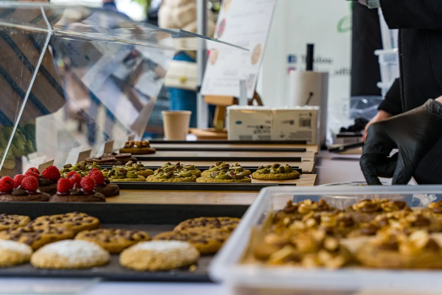 Étal de pâtisseries : tartelettes aux fruits, cookies et gâteaux alignés en vitrine