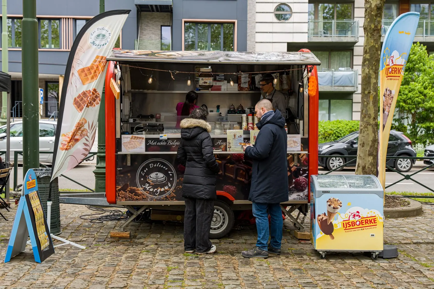 Remorque à gaufres et glaces, deux clients au comptoir sur les pavés